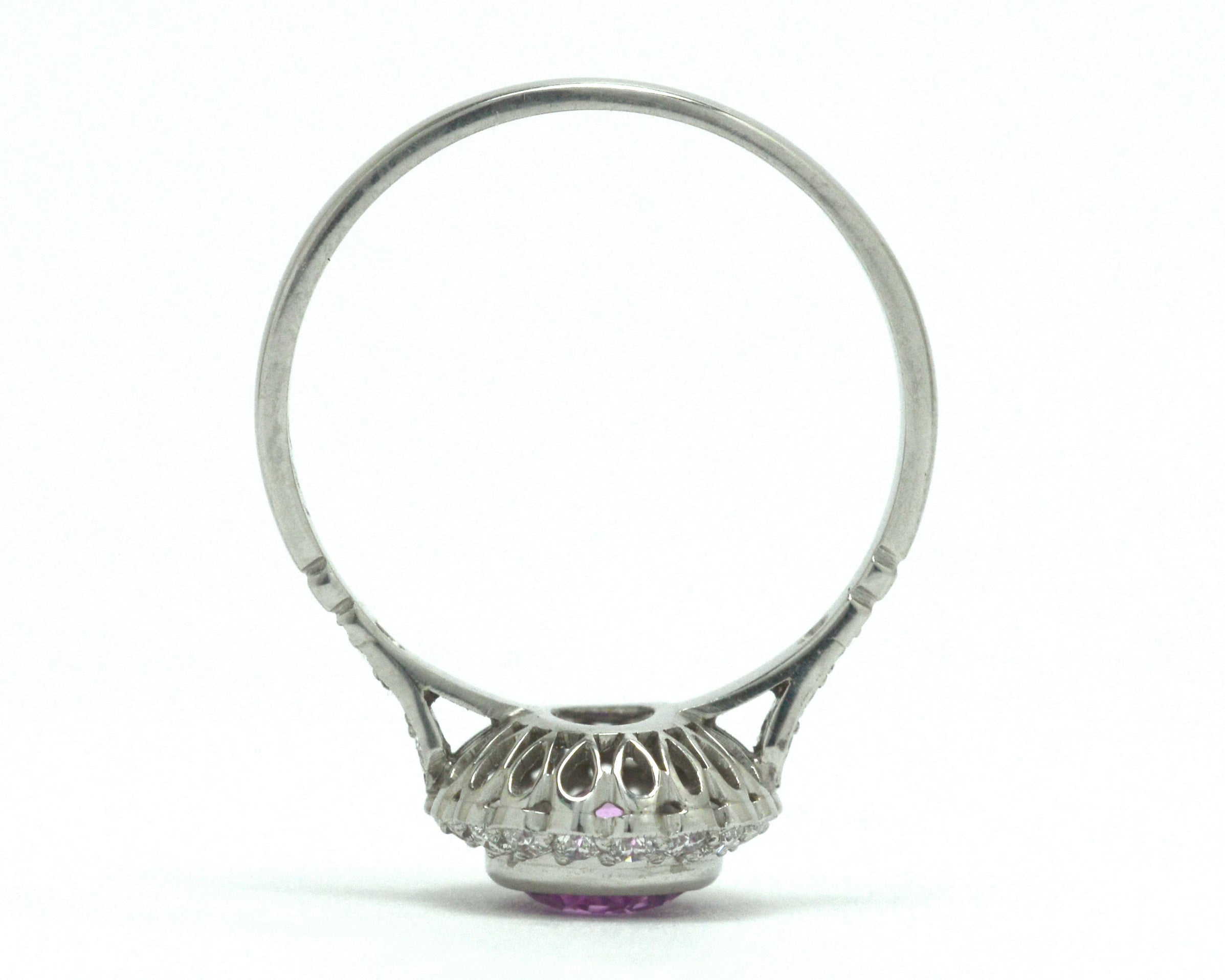 A platinum foliate scrolled under-crown engagement ring. 