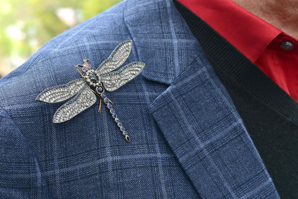 A diamond and sapphire dragonfly brooch with pink sapphire eyes.