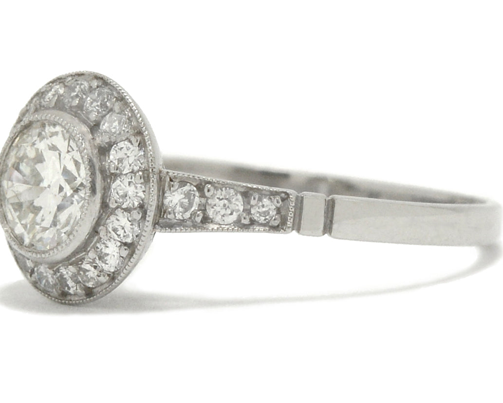 A round, old European diamond is surrounded by a halo in this engagement ring.
