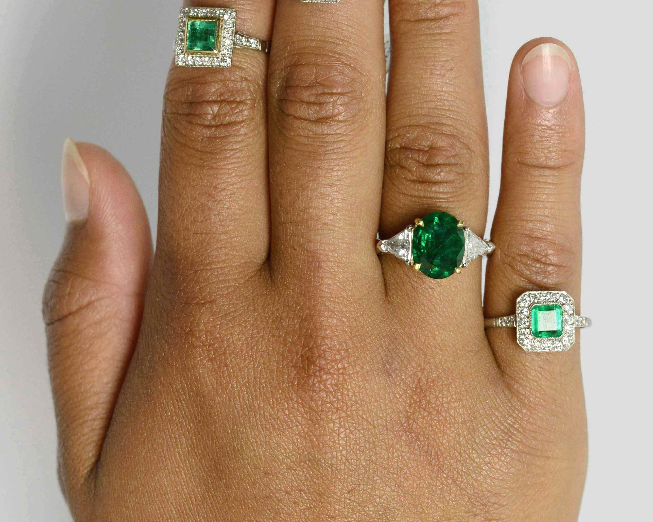 A collection of emerald and diamonds halo engaement rings.