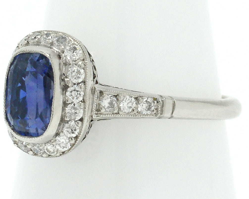 Old European diamonds line the 3 carat unheated sapphire in this halo engagement ring.