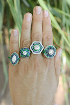 Some of our diamond halo engagement rings with blue sapphire and emerald accents.