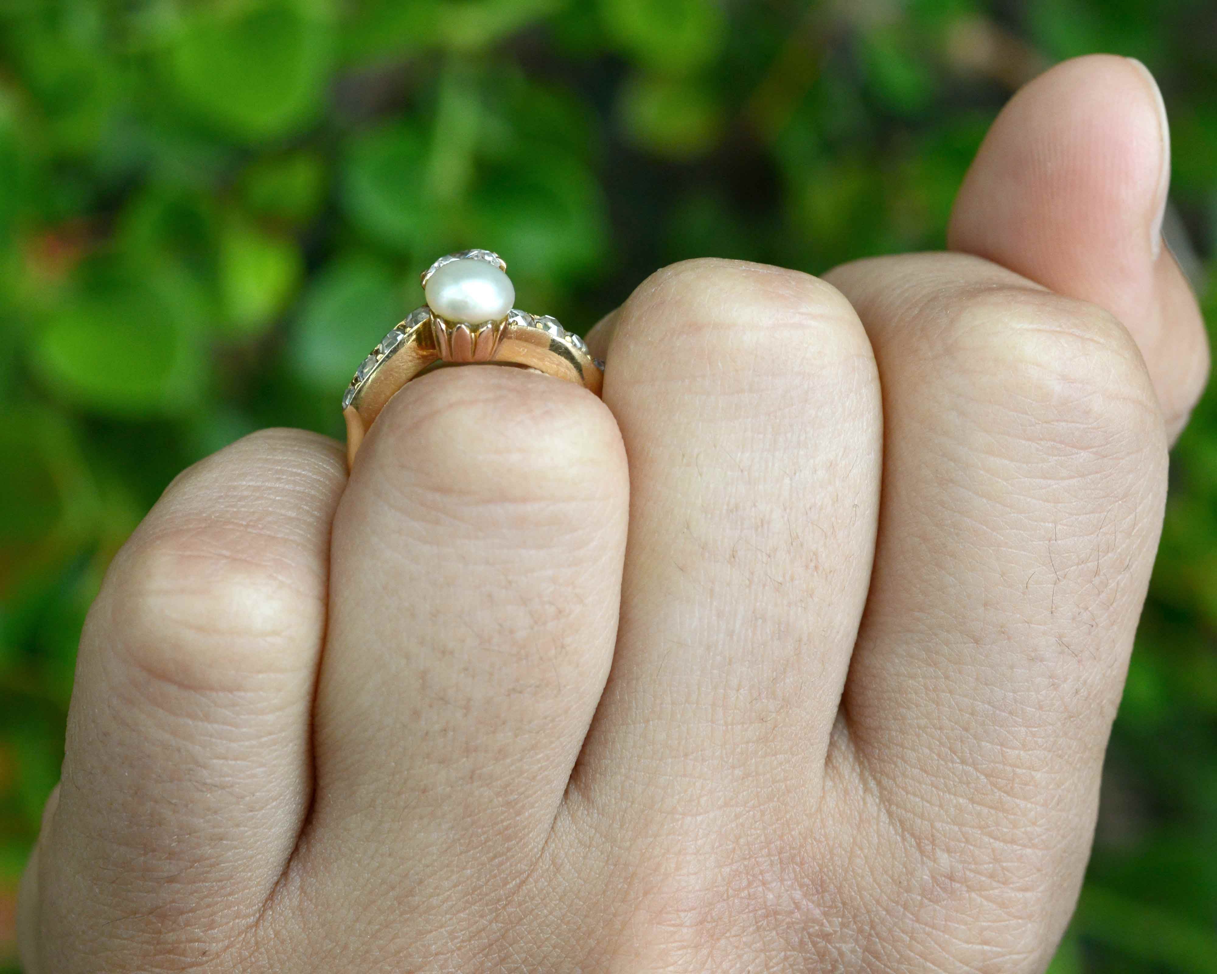 This gold solitaire ring features a pearl and diamonds.