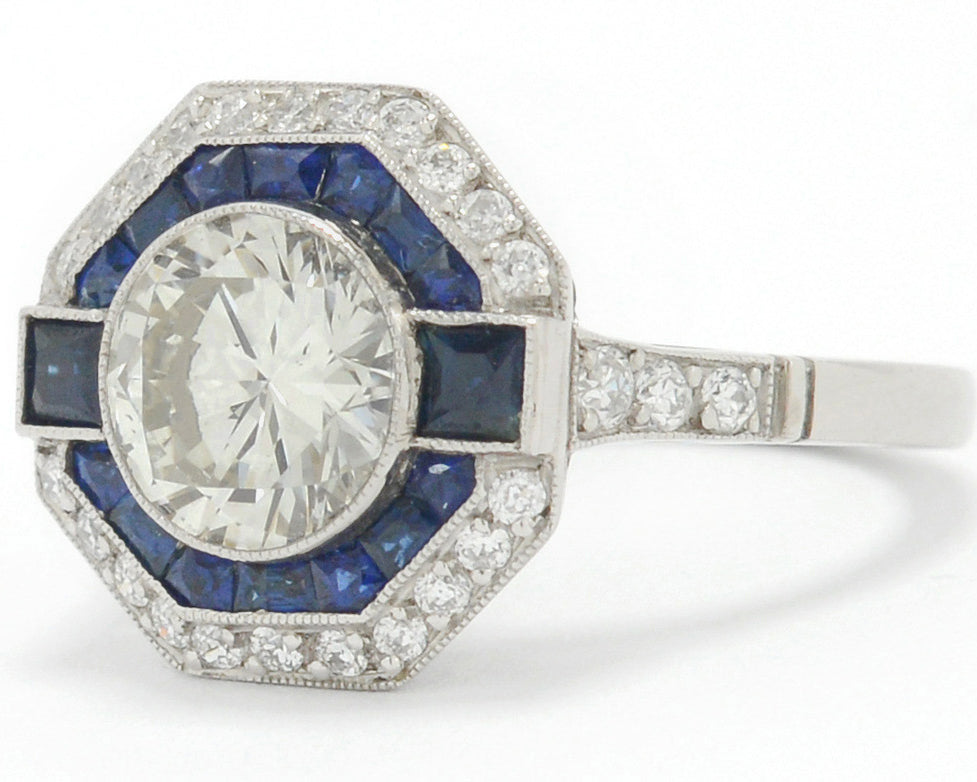 A 2 carat round brilliant diamond octagon engagement ring with a halo of sapphires.