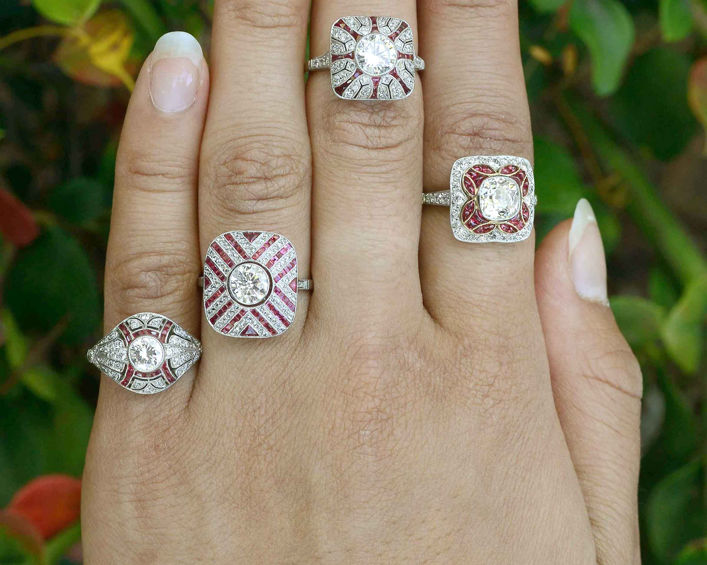 A collection of diamond with ruby accent, platinum engagement rings.