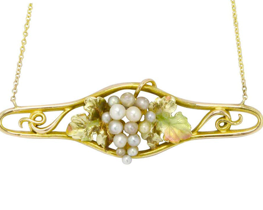 A cluster of seed pearls center an enamel grape design, gold necklace.