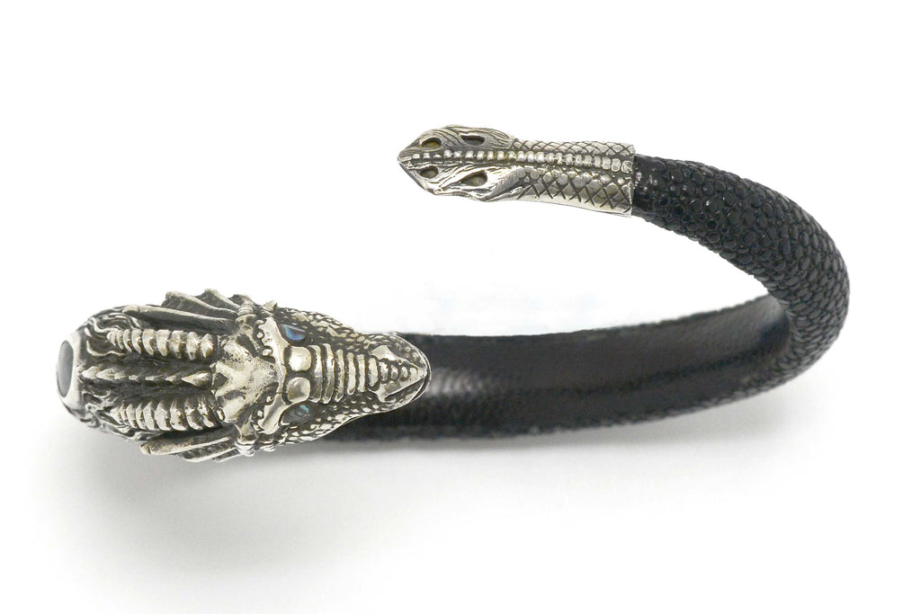 Silver arm cuff bangle and black leather wrap bracelet.