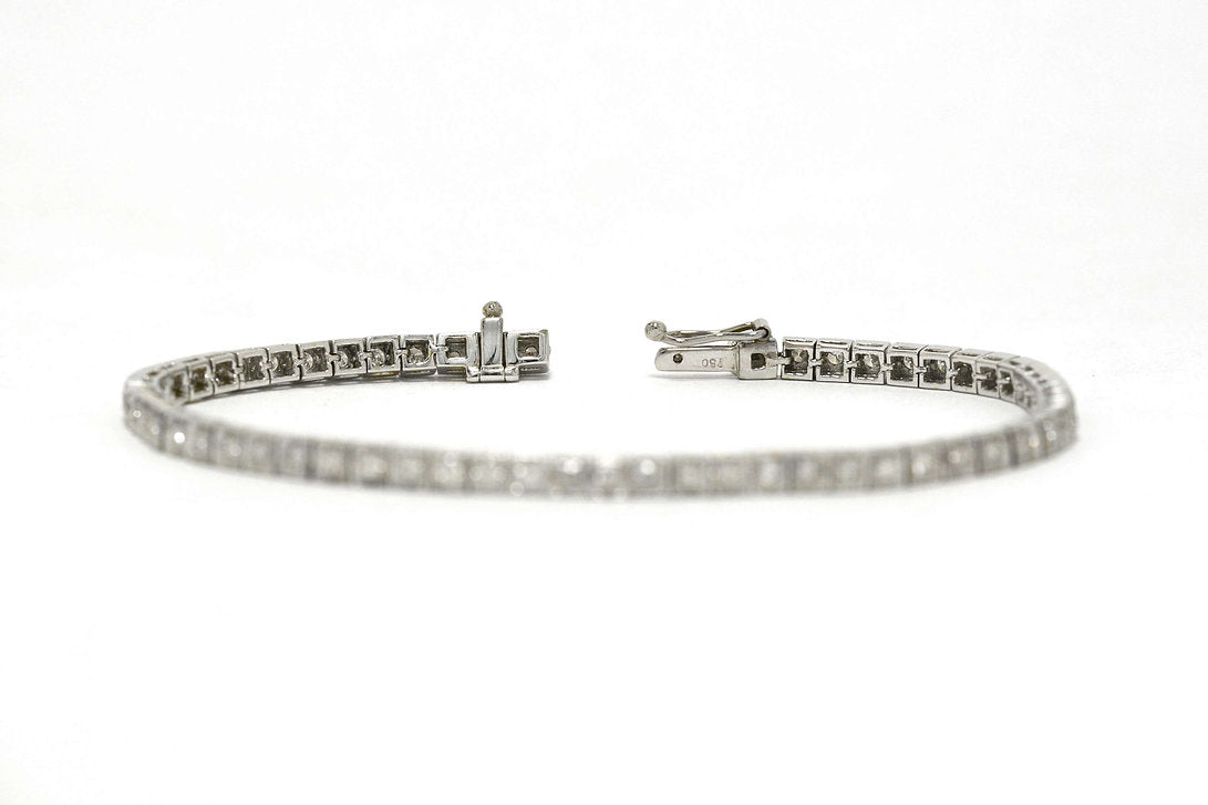 A slide lock and safety clasp keeps this white gold tennis bracelet secure.