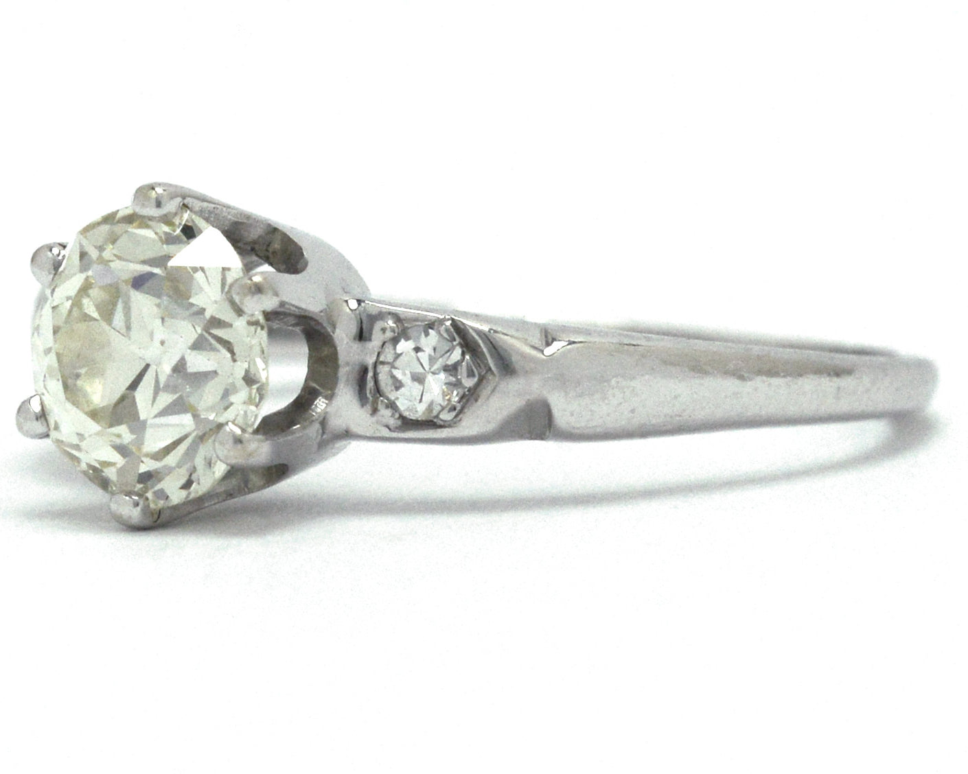 A Tiffany style solitaire engagement ring with a slightly yellow diamond.