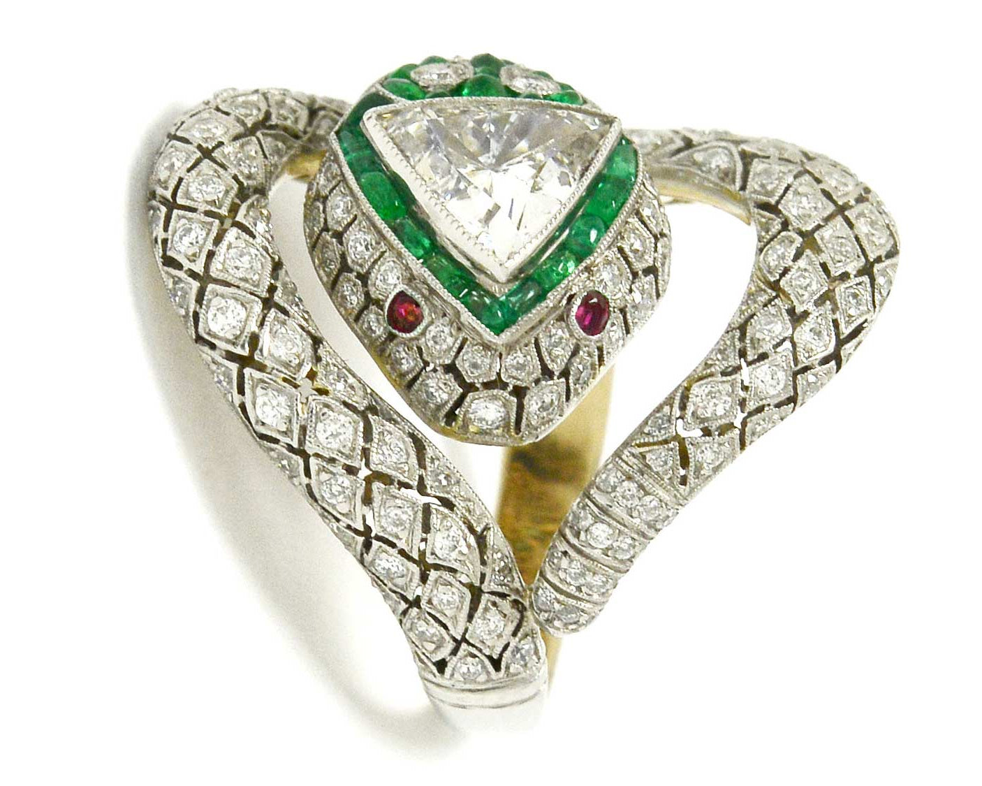 A platinum diamond snake ring with ruby eyes, emeralds surround the trillion cut diamond.