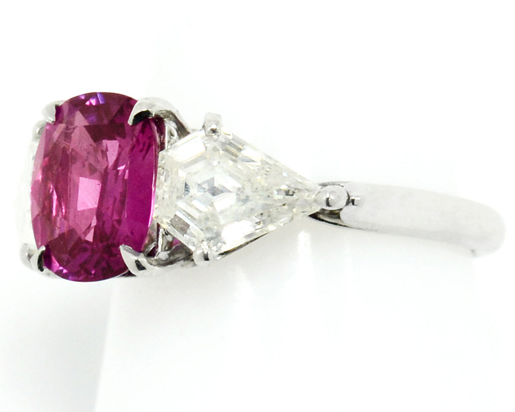 A 2 carat pink sapphire 3 stone platinum engagement ring with diamonds.