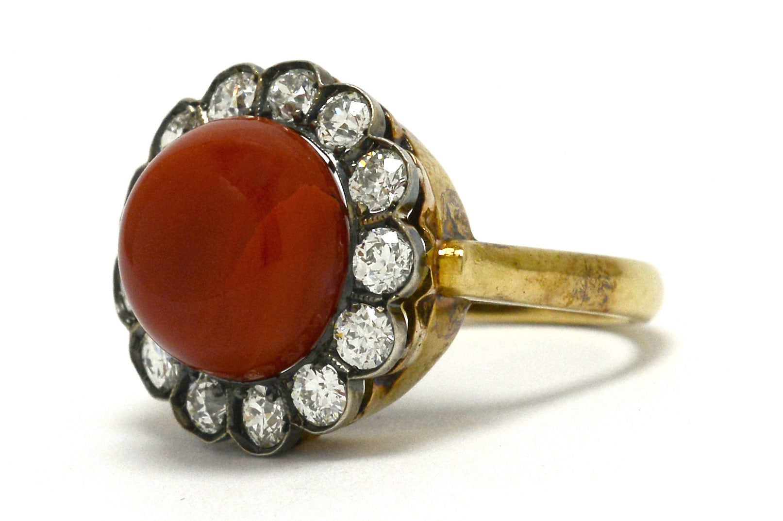 An antique, Victorian coral ring with a halo of diamonds.