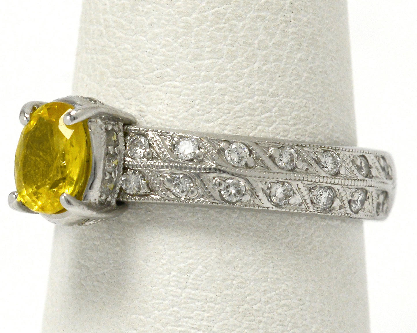 At nearly 1 carat, this golden yellow sapphire is secured by 4 prongs in this band.